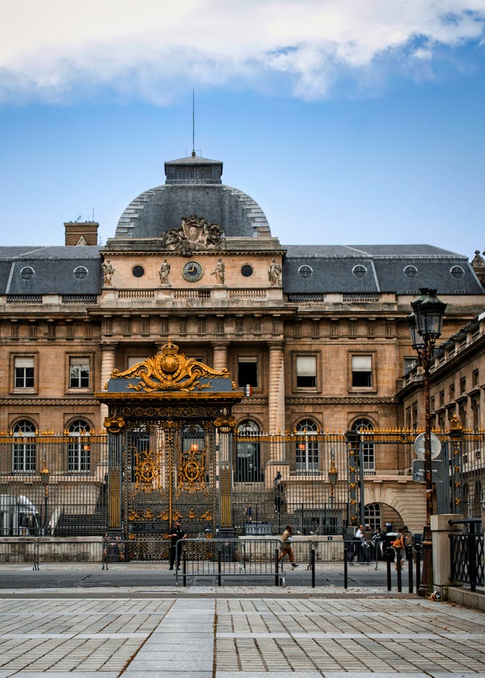 Explore the grandeur of Paris with this classic view of the Palais de Justice, featuring ornate gates and stunning architecture.
